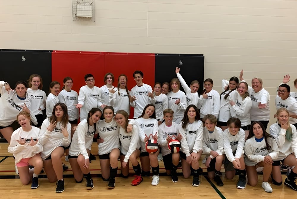 Eine große Gruppe junger Schülerinnen in Sportuniformen versammelt sich in der Turnhalle der North Grenville District High School.