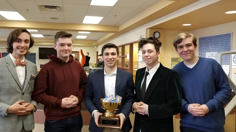Fünf Schüler der North Grenville District High School posieren gemeinsam mit einem Pokal in einem Flur mit Spinden.