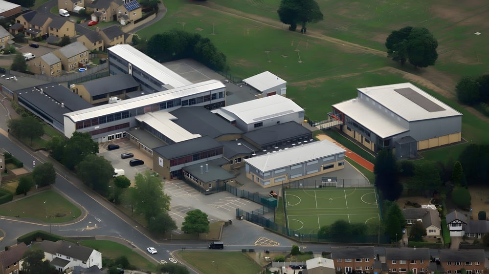 Luftaufnahme des Campus der North Halifax Grammar School mit Gebäuden, Sportfeld und umgebender Grünfläche.