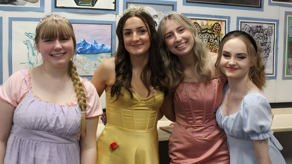 Vier Schülerinnen der North Halifax Grammar School stehen vor einer Wand mit verschiedenen gerahmten Kunstwerken.