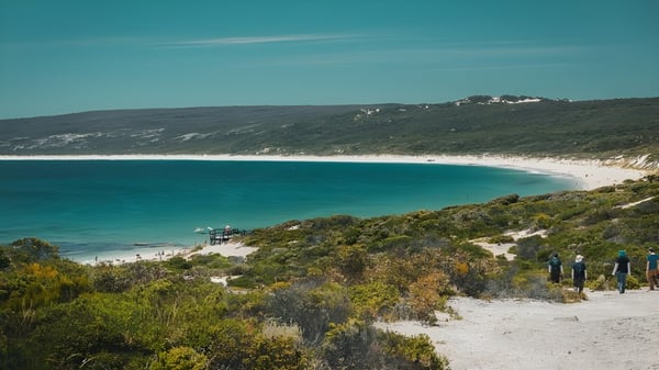 Eine Küstenlandschaft mit Sandstrand und türkisfarbenem Wasser nahe dem North Lake Senior Campus.