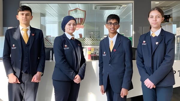 Vier Schülerinnen und Schüler der North London Grammar School stehen im Schulflur.
