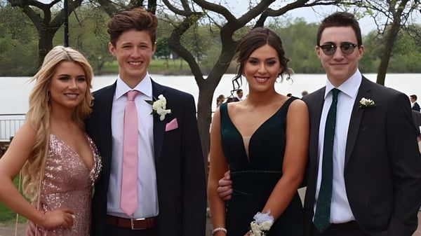 Vier Personen stehen auf dem Gelände der North Star High School vor Bäumen und einem See.