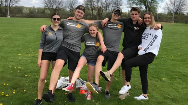 Eine Gruppe von Schülerinnen und Schülern steht auf dem Sportplatz der North Star High School im Freien.