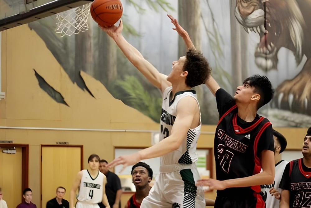 Zwei Basketballspieler kämpfen um den Ball vor einem Waldgemälde auf dem Gelände der North Surrey Secondary School.