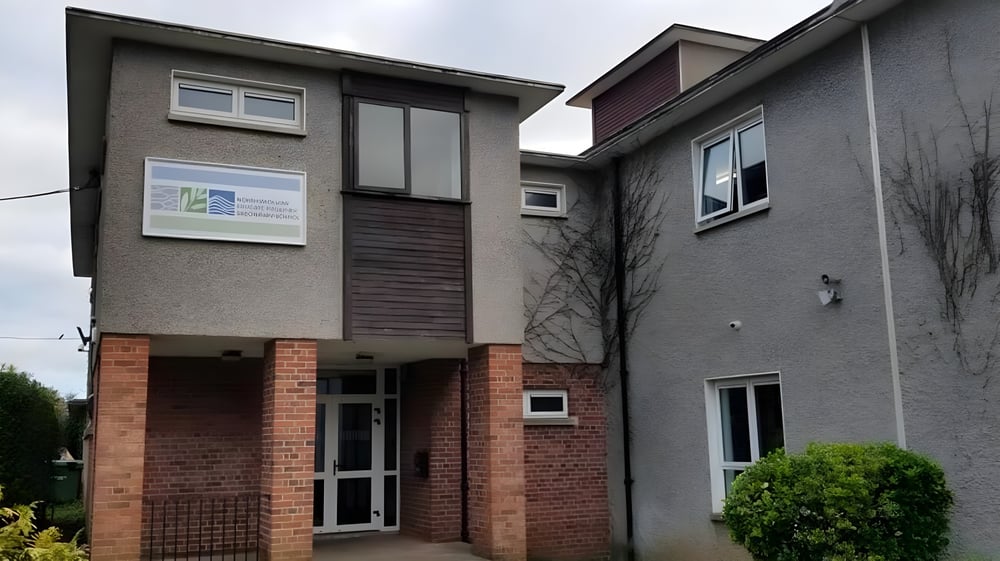 Das mehrstöckige Wohngebäude mit gemischter Backstein- und Putzfassade steht vor der North Wicklow Educate Together Secondary School.