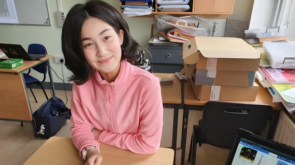 Eine junge Frau sitzt in einem beengten Büro auf dem Campus der North Wicklow Educate Together Secondary School.