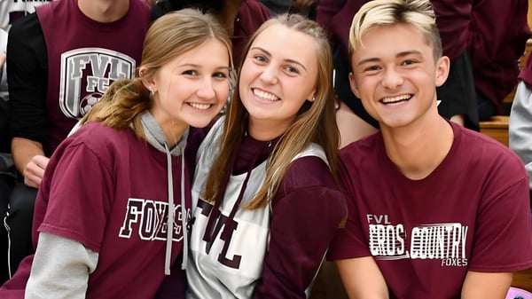 Drei Schülerinnen der Northeastern Wisconsin Lutheran High School lächeln zusammen in einer Schulumgebung.