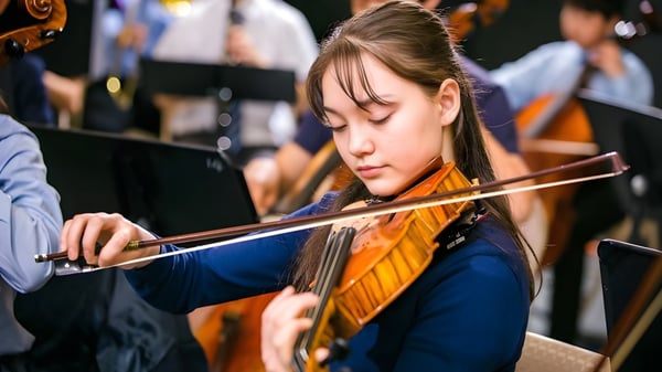 Eine Schülerin der Northern Academy spielt konzentriert Geige während einer musikalischen Aufführung.