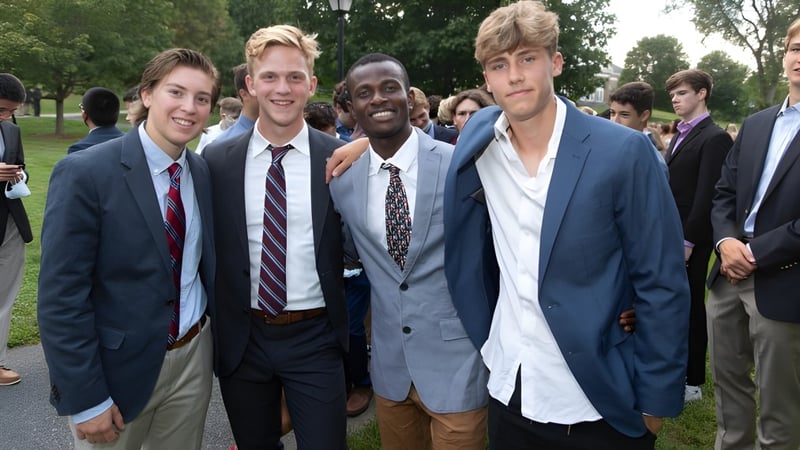 Eine Gruppe junger Männer in formeller Kleidung steht im Freien auf dem Campus der Northfield Mount Hermon School.