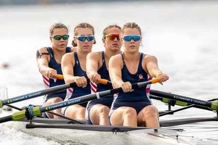 Vier Schülerinnen und Schüler von Northfield Mount Hermon trainieren im Ruderboot auf dem Wasser.