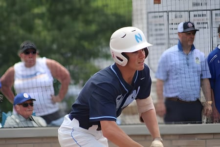 Ein junger Baseballspieler steht in Uniform im Vordergrund auf dem Sportgelände der Northpoint Christian School.
