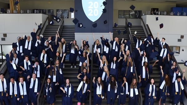 Eine Gruppe von Schülern der Northpoint Christian School versammelt sich auf einer Treppe in Abschlusskleidung zur Feier des erfolgreichen Schulabschlusses.