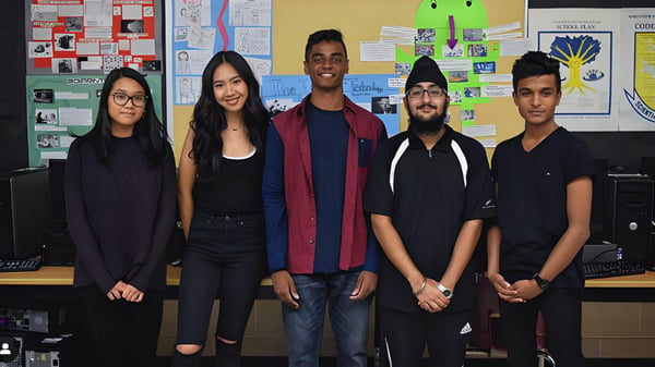 Eine Gruppe von fünf Schülerinnen und Schülern steht gemeinsam in einem Klassenzimmer der Northview Heights Secondary School.