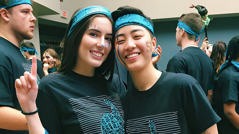 Zwei Schülerinnen mit blauen Stirnbändern posieren zusammen in einem Innenraum auf der Northview Heights Secondary School.