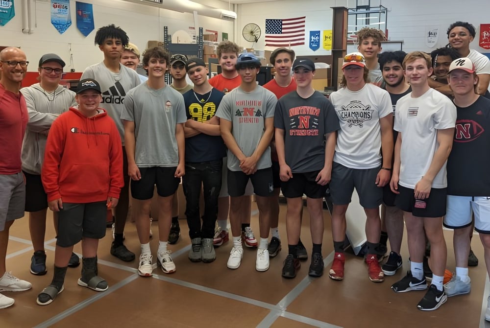 Eine Gruppe Schüler steht gemeinsam in einem Klassenraum auf dem Campus der Northview High School mit Fahnen im Hintergrund.