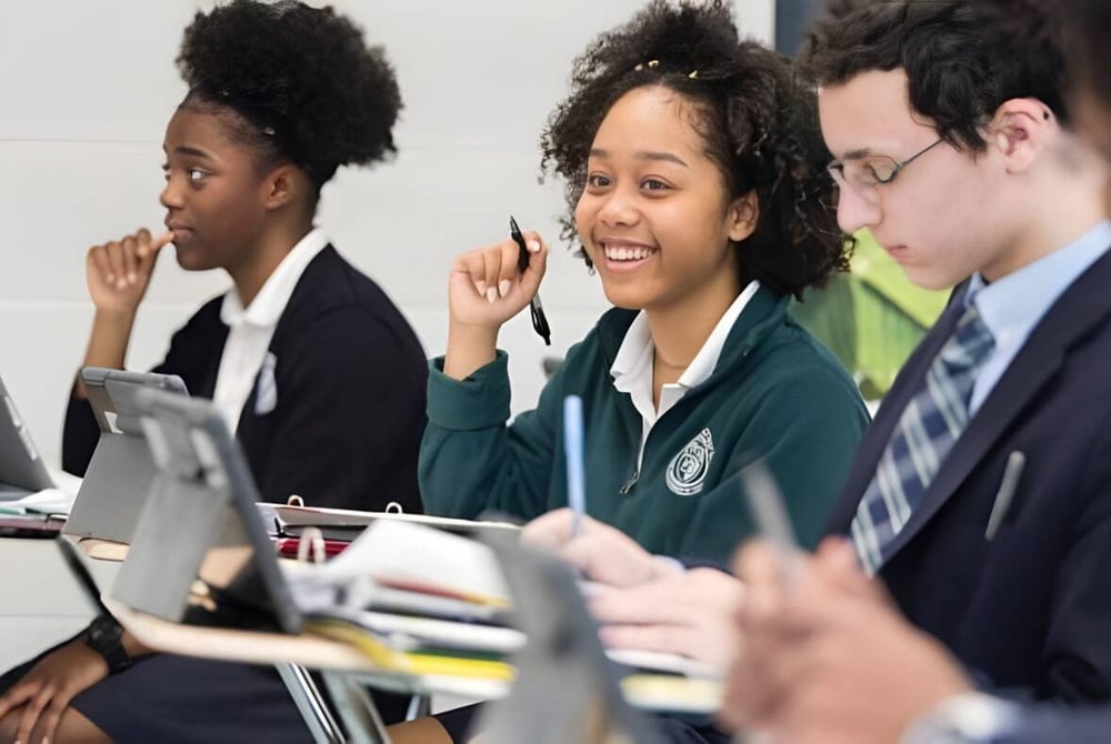 Schüler der Northwest Catholic High School arbeiten gemeinsam an einem Lernprojekt mit Laptops im Klassenraum.