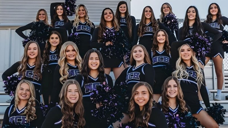 Eine Gruppe Cheerleaderinnen in einheitlichen Uniformen posiert vor einem Metallverschlag auf dem Campus der Northwest Christian High School.