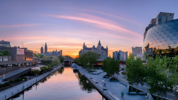 Eine ruhige Stadtansicht mit einem Kanal im Vordergrund nahe der Notre Dame High School bei Sonnenuntergang.