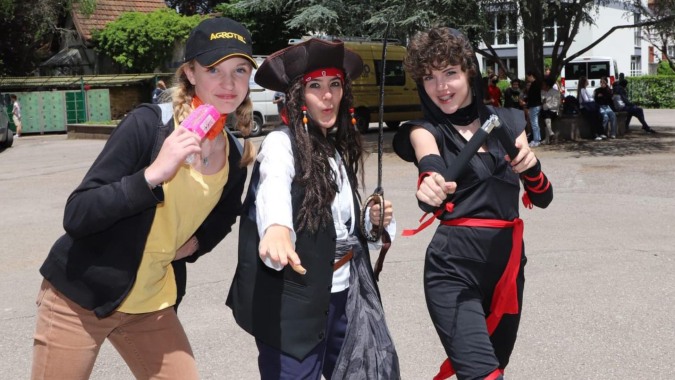 Drei Personen stehen im Außenbereich vor Gebäuden auf dem Campus der Notre Dame Saint Joseph.