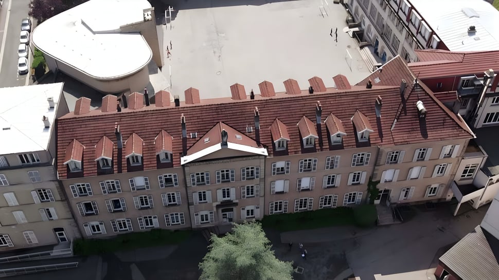 Das historische Backsteingebäude mit auffälliger Dachlinie auf dem Campus der Notre Dame Saint Joseph School.