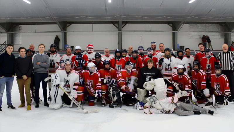 Eine Gruppe von Schülerinnen und Schülern der Nottawasaga Pines Secondary School steht in ihren Hockeyuniformen auf der Eisfläche einer Halle.