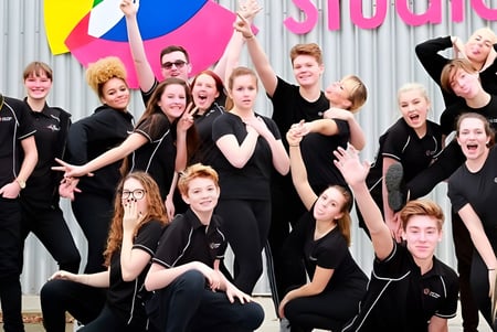 Eine Gruppe junger Frauen posiert vor einem bunten Hintergrund im Oak Leaf Studio.
