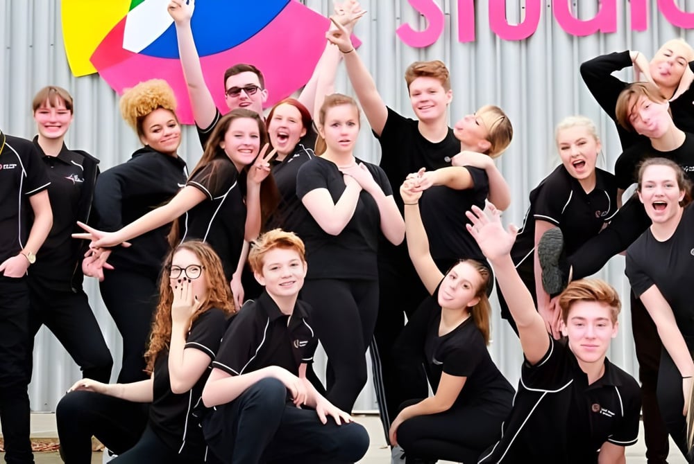 Eine Gruppe junger Frauen posiert vor einem bunten Hintergrund im Oak Leaf Studio.