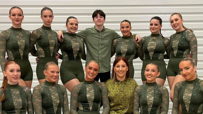 Eine Gruppe von Frauen in Militäruniformen posiert vor einer grauen Wand auf dem Gelände von Oak Leaf Studio.