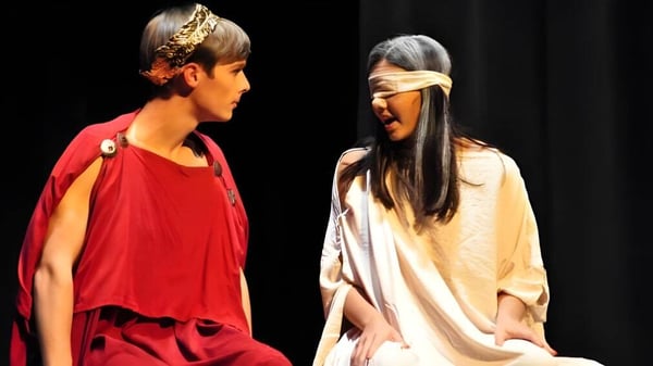 Zwei Schüler in bunten Kostümen stehen auf der Bühne im Theater der Oak Mountain Academy.