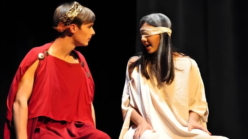 Zwei Schüler in bunten Kostümen stehen auf der Bühne im Theater der Oak Mountain Academy.