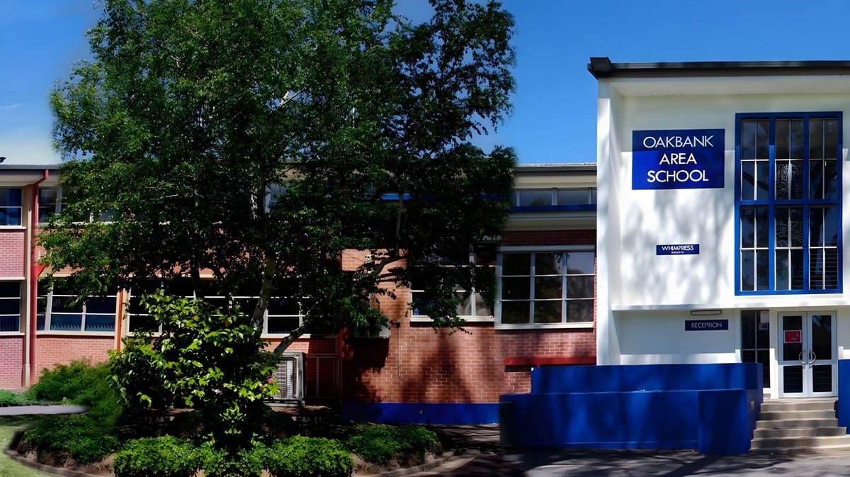 Das Backsteingebäude der Oakbank Area School ist von Bäumen und Grünflächen umgeben.