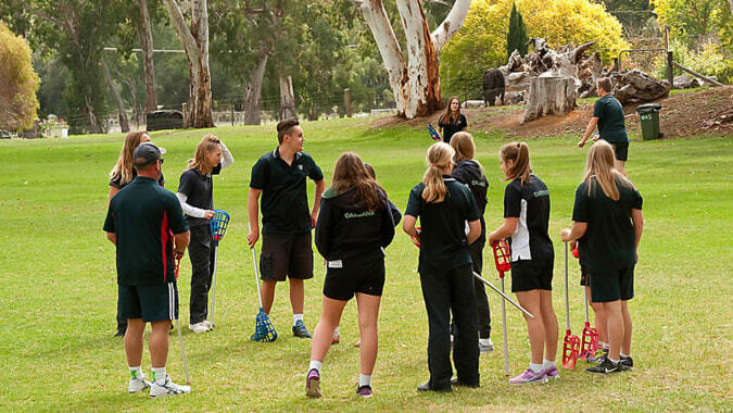 Eine Gruppe Schülerinnen der Oakbank Area School steht in Sportkleidung auf einem grasbewachsenen Feld im Freien.