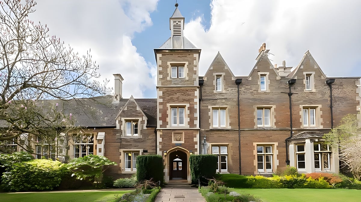 Das historische Gebäude der Oakham School ähnelt einem steinernen Schloss mit einem hohen Turm und ist von gepflegten Grünflächen umgeben.