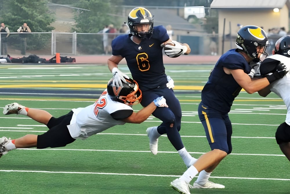 Schüler der Oakridge Secondary School spielen American Football während eines intensiven Spiels auf dem Spielfeld.