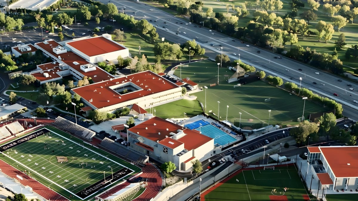 Luftaufnahme des Campus mit mehreren Gebäuden und Sportplätzen der Oaks Christian School.
