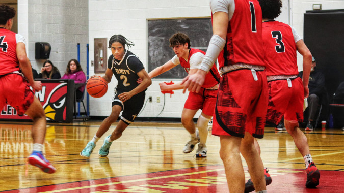 Schülerinnen und Schüler der Oakville Trafalgar High School spielen ein Basketballspiel in der Turnhalle vor Zuschauern.