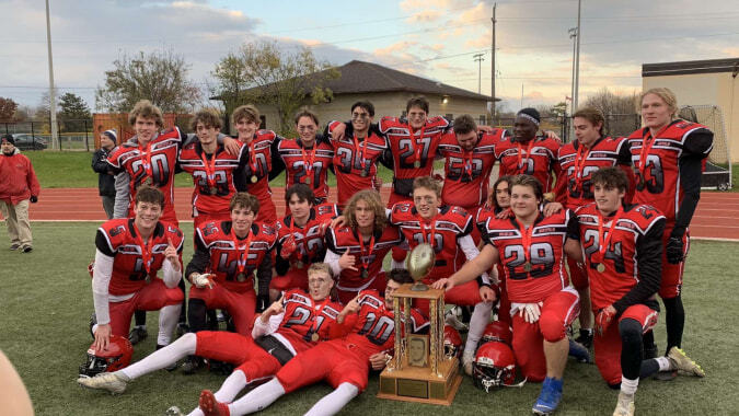 Schüler der Oakville Trafalgar High School posieren auf dem Sportfeld mit einem Pokal in den Händen.