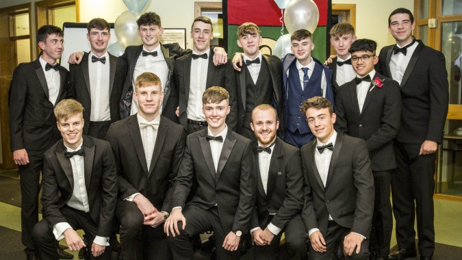 Eine Gruppe junger Männer in formeller Kleidung bei einer Feier auf dem Campus von Oatlands College.