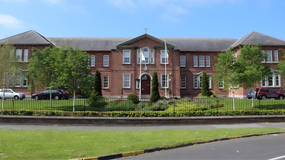 Das Oatlands College zeigt ein großes Backsteingebäude mit zentralem Turm und gepflegtem Rasen im Außenbereich.