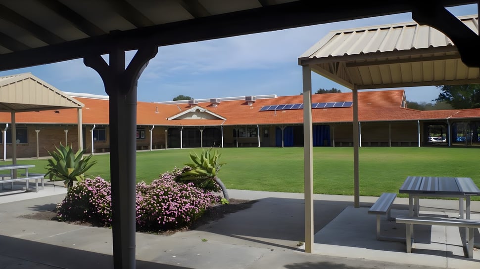 Überdachter Außenbereich mit Sitzbänken und Tischen auf dem Campus der Ocean Reef Senior High School.