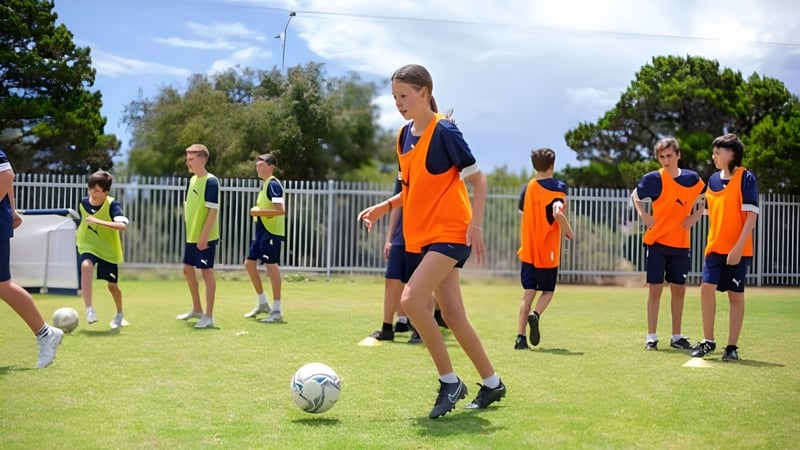 Eine Gruppe von Schülern der Ocean Reef Senior High School steht im Fußballtrikot auf einem Spielfeld mit Bäumen im Hintergrund.