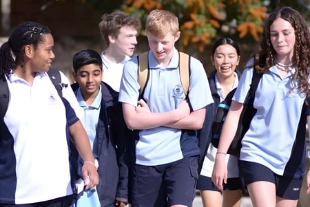 Eine Gruppe von Schülern der Ocean Reef Senior High School steht gemeinsam draußen vor herbstlichem Laub.