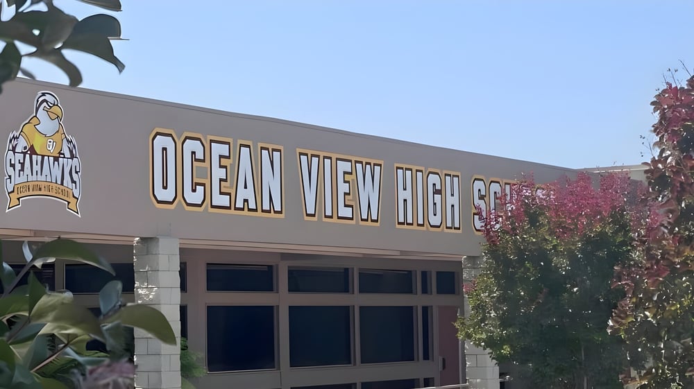 Das Gebäude der Ocean View High School ist mit Bäumen und Sträuchern im Vordergrund zu sehen.