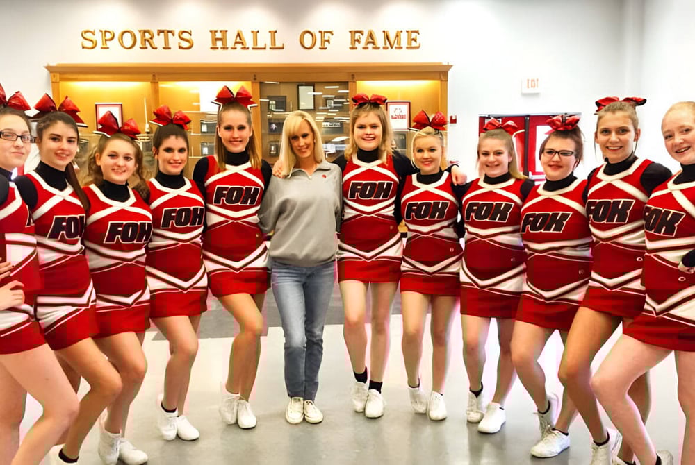 Eine Gruppe Cheerleader der O'Donel High School posiert vor dem Schild der Sports Hall of Fame.