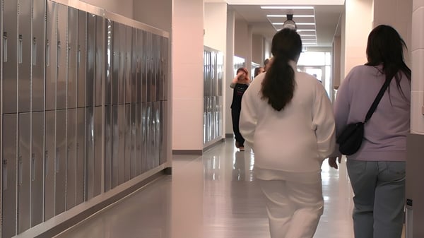 Schüler gehen den Flur mit Spinden an der Wand in der Ohpaho Secondary School entlang.