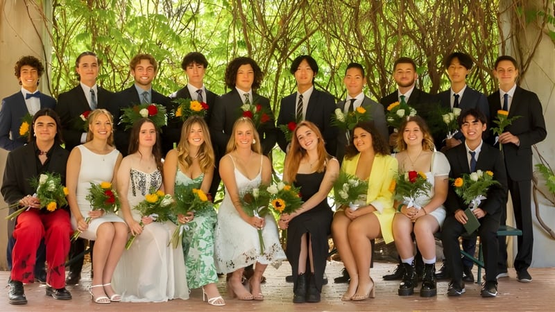 Eine Gruppe von Personen in festlicher Kleidung posiert im Grünen auf dem Gelände der Ojai Valley School.