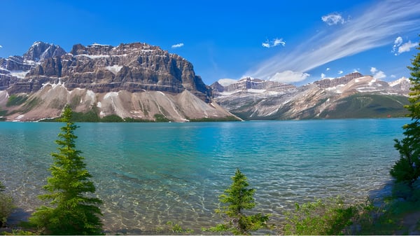 Blick auf einen alpinen See mit schneebedeckten Bergen und Nadelbäumen in der Nähe der Okanagan Mission Secondary School.