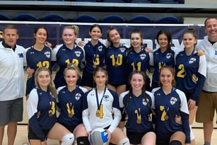 Eine Gruppe junger Sportlerinnen der Okanagan Mission Secondary School posiert gemeinsam in einer Turnhalle.