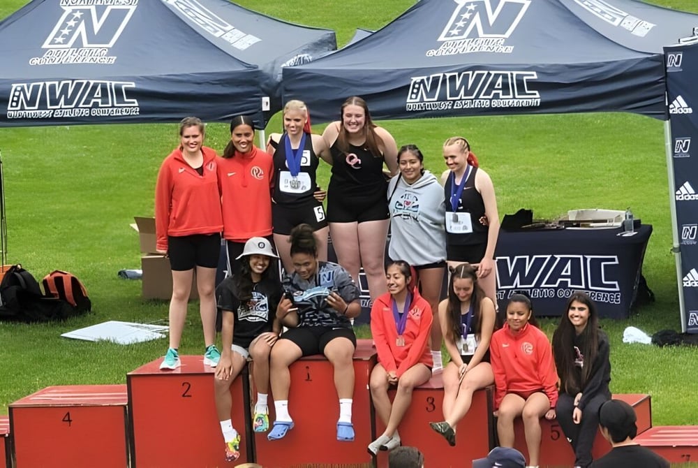 Junge Sportlerinnen der Olympic College stehen auf einem Podium während eines WAC-Events.